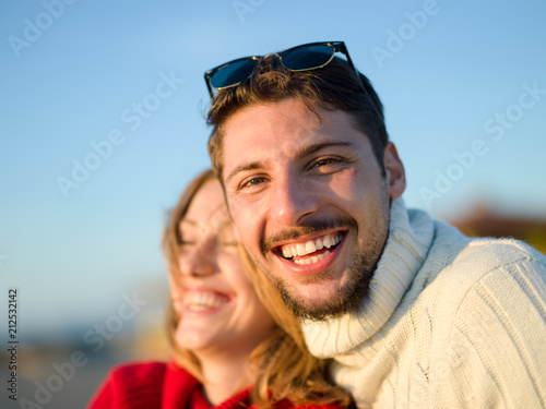 couple on a beach at autumn sunny day