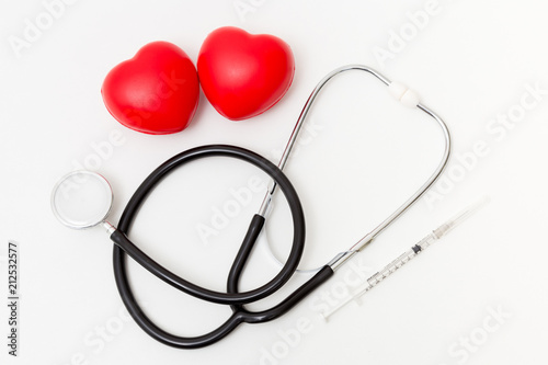 Red heart with a stethoscope and syringe. Isolated on white background. Studio lighting. Concept for healthy and medical