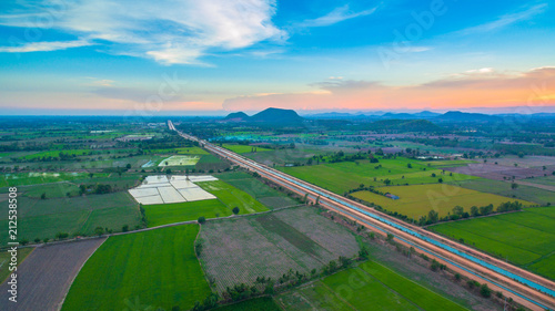 aerial view scenery sunset on new route pass in the rice field. under construction new motorway connect to Myanmar.