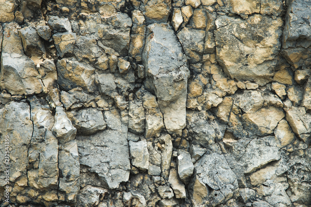 Pebble stones in a rocky wall. Natural background of a rocky stone wall Pebble stones in a rocky wall. Natural background of a rocky stone wall