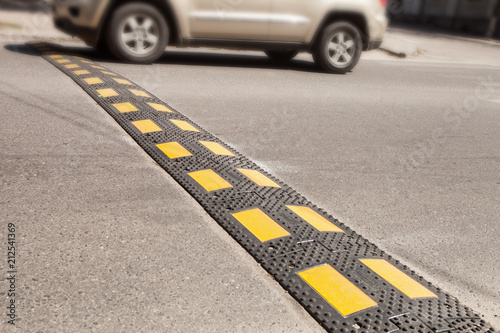 Obraz na plátne A car moving an artificial unevenness to reduce speed on the road