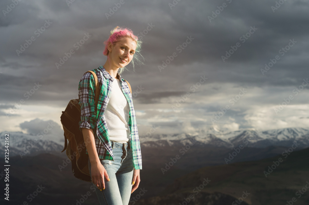 A student girl outdoors in the countryside on a summer summer journey smiling. Caucasian female college or university student on a hike