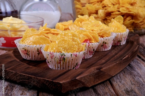 Bowl with cornflakes, conflakes cup, suger, butter and honey on  wooden background photo