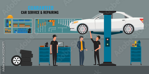 Auto repair shop interior with mechanics or masters working and fixing cars, professional service concept and talking to a client. Car on the lift. Tools panel on wall.