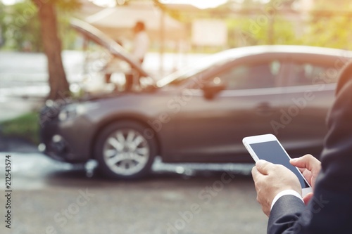 Fotografie close up businessman hand using a mobile smart phone call a car mechanic ask for help assistance because car broken roadside