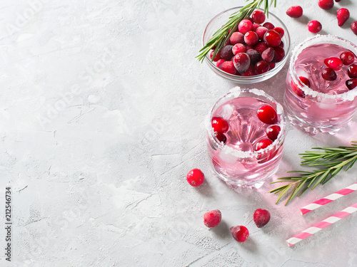 Cranberries cocktails with ice, berries and rosemary