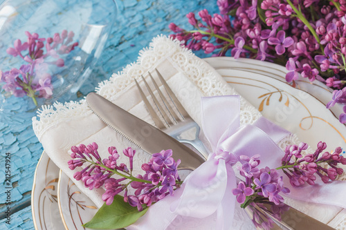 Tableware and silverware with bouquet of light violet lilac