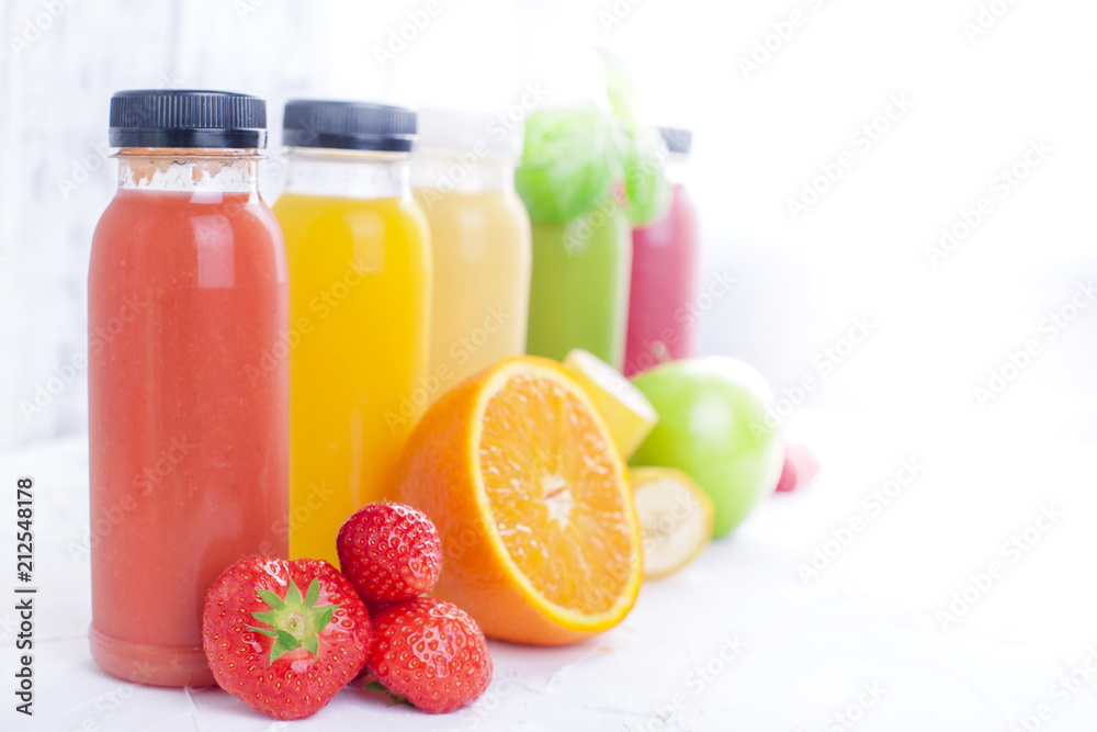 Many different fruits and berries and juices in plastic bottles. Watermelon, banana, applcsin, blueberries, strawberries, basil on a white background. Vitamin and healthy food. Detox. Copy space. Many different fruits and berries and juices in plastic bottles. Watermelon, banana, applcsin, blueberries, strawberries, basil on a white background. Vitamin and healthy food. Detox. Copy space.