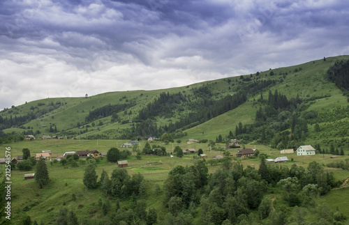 Photo of mountain village in the summer under beautiful cloudy sky. Ukraine  Carpathians  Dzembronia