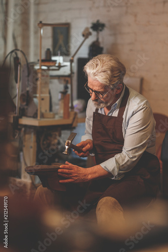 Fotografie An elderly shoemaker in studio