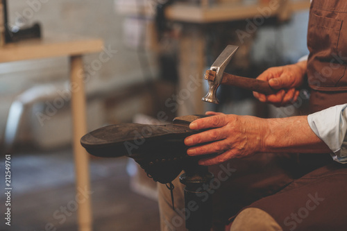 An elderly shoemaker at work