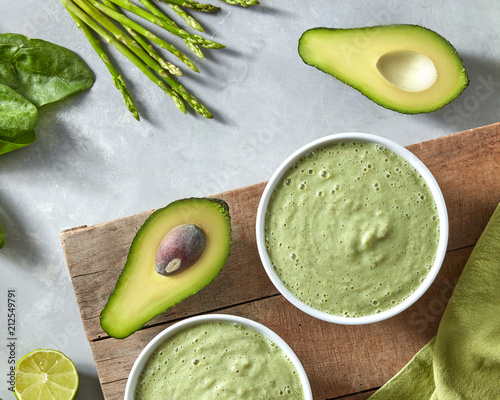 Breakfast of fresh green smoothies in a pial with avocado on a concrete background with a green napkin top view photo