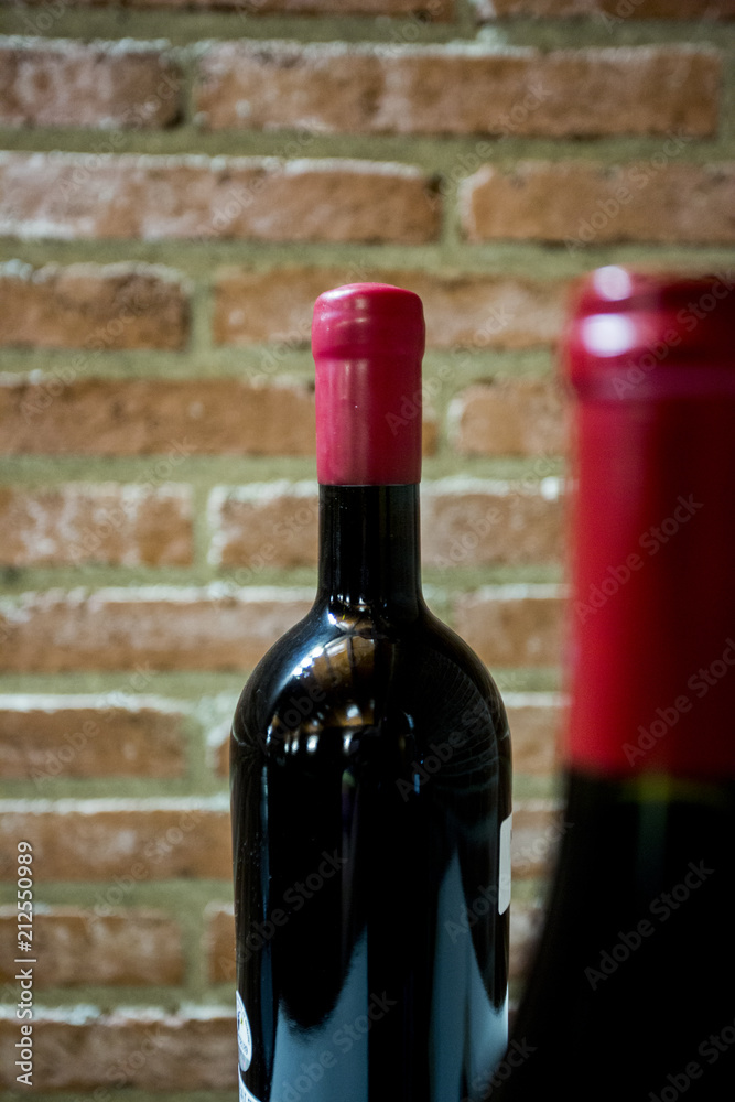 Bottles of red wine on a brick wall background