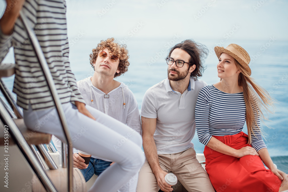 acation, travel, sea, friendship and people concept - friends talking while having a sea travel to islands sitting on yacht deck