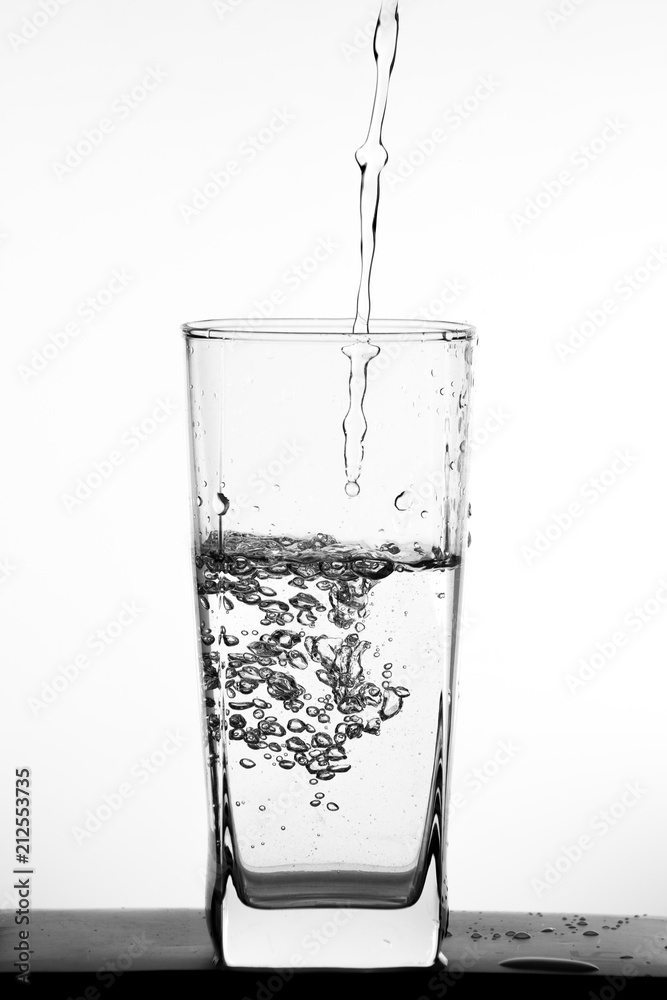 Water pouring into the clear glass Water pouring into the clear glass