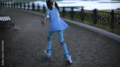 Wallpaper Mural a girl in blue leggings and blue t-shirts roller skate along the promenade in the rain on a summer evening. Torontodigital.ca