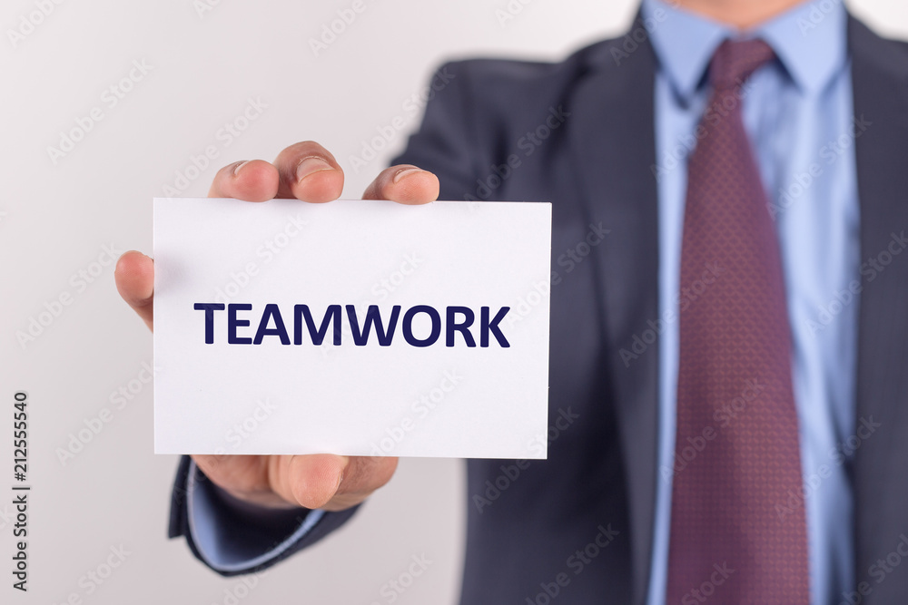 Man showing paper with TEAMWORK text Man showing paper with TEAMWORK text