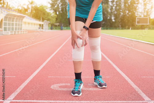 Woman runner suffering from pain in legs be injured after running jogging,Hands touching her knee