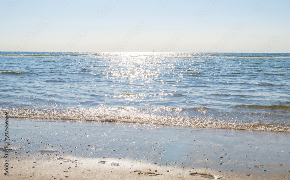 Beach along the North Sea below a blue sky in sunlight in summer Beach along the North Sea below a blue sky in sunlight in summer