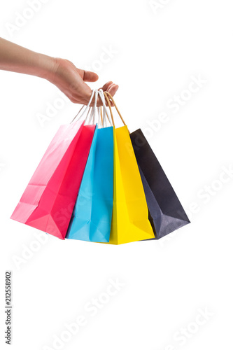 Hand holding colourful paper shopping bags isolated on white background.