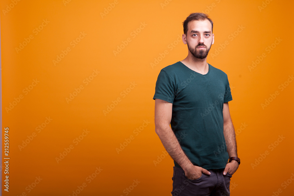 Serious handsmone man posing in studio on yellow background Serious handsmone man posing in studio on yellow background