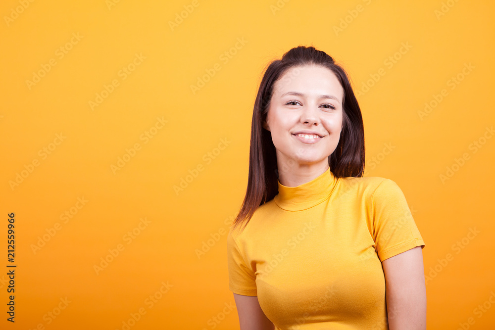 Portrait of cute young woman smiling in studio photo on yellow background Portrait of cute young woman smiling in studio photo on yellow background