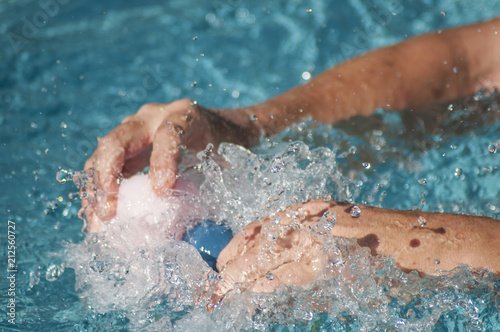 closeup of hands of man splashing with plastic rubber ducks toys in swimming pool © pixarno