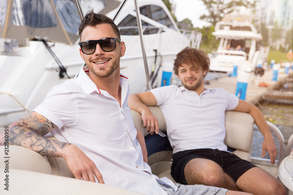 Two young guys are resting on yacht