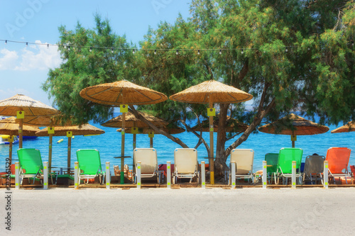 Beach straw umbrellas and sunbeds in the morning sunlight. Concept-  tourism  vacation by the sea.