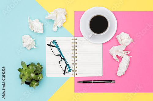 Writer's block. Ideas, brainstorming, creativity, imagination, deadline, frustration concept. Top view photo of office desk with blank mock up open notepad and crumpled paper on pastel background.  photo