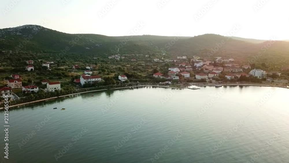 Aerial: Evening flight in front of village Mrljane on island Pasman in Croatia. Shot on vacation in Adriatic sea at Mediterranean coastline.