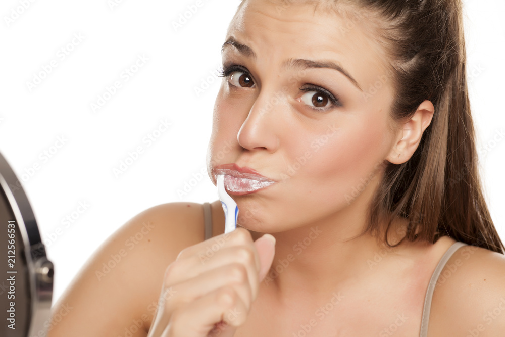 young happy woman brushing her teeth on white background young happy woman brushing her teeth on white background