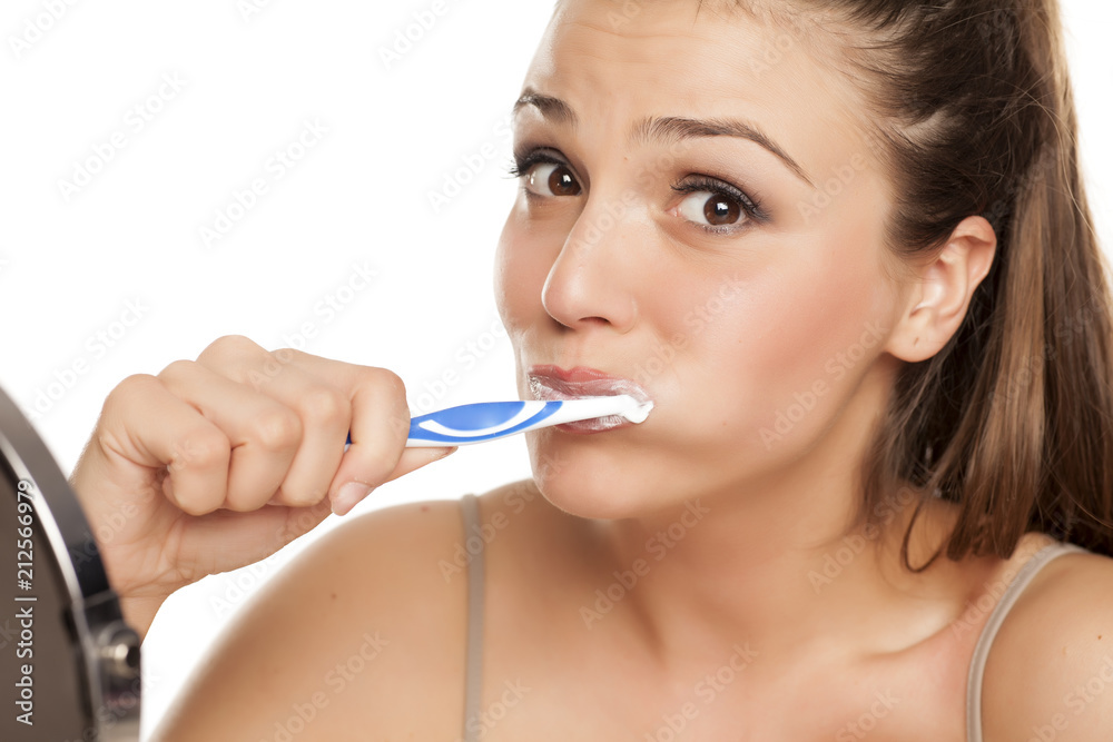 young happy woman brushing her teeth on white background young happy woman brushing her teeth on white background