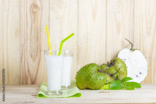 Fotografija Soursop juice with soursop fruit on wooden table.