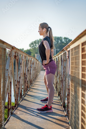 Sport and fitness. Young woman training outdoor at sunrise with urban background. © PhotoGranary
