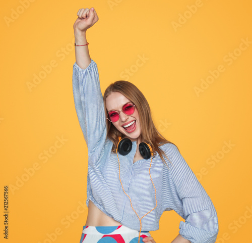 Young woman with headphones celebrating victory