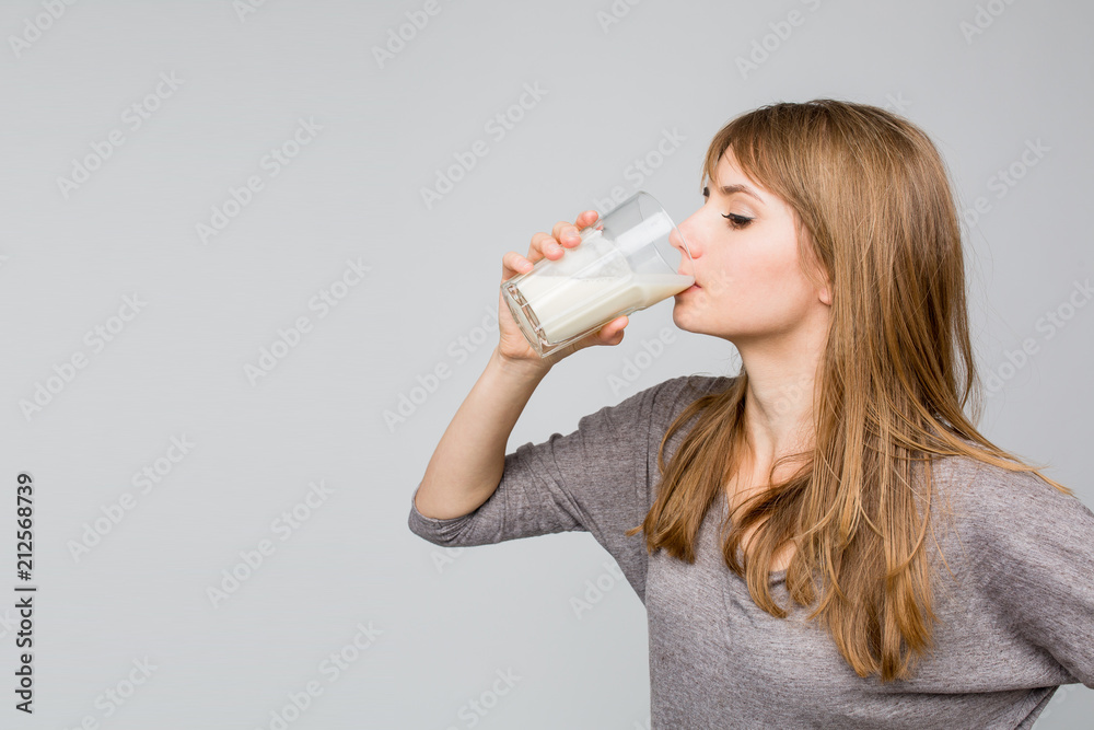 Young woman drinking milk over white background Young woman drinking milk over white background