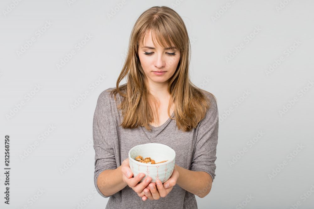 Young woman holding a bowl with almonds Young woman holding a bowl with almonds