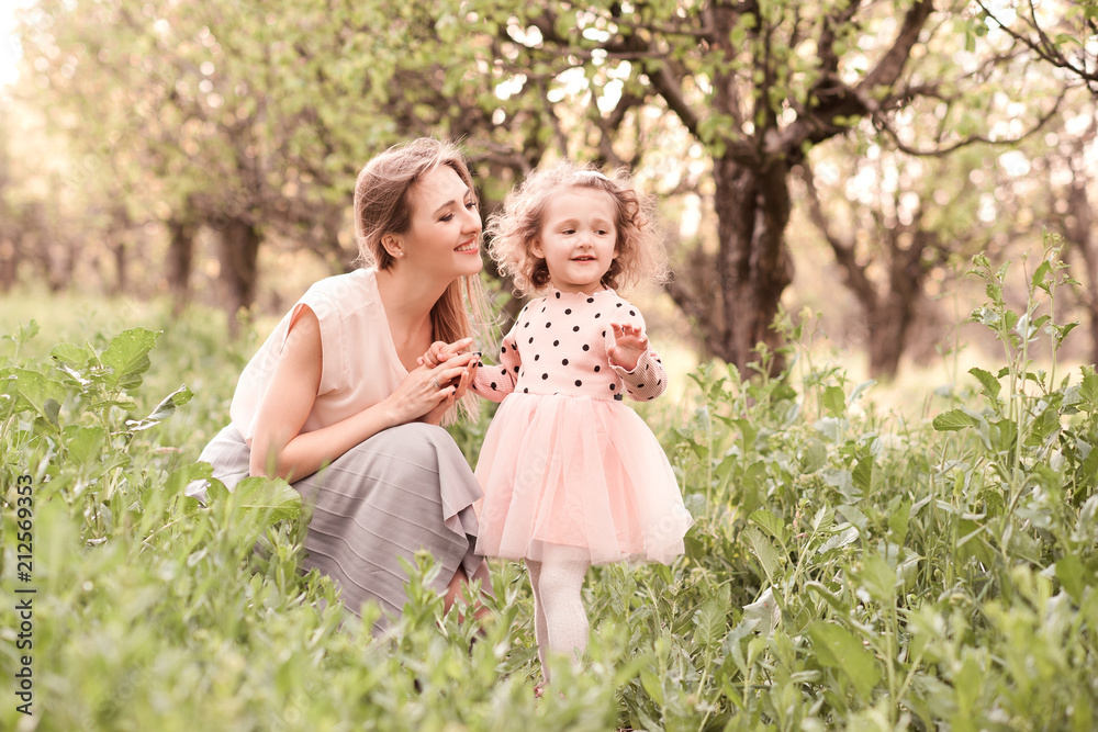 Fototapeta premium Happy mother holding child girl 3-4 year old outdoors. Motherhood.