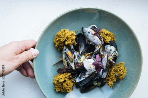 Crop chef preparing exotic mussels dish photo