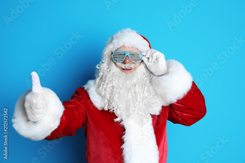 Authentic Santa Claus wearing funny glasses on color background