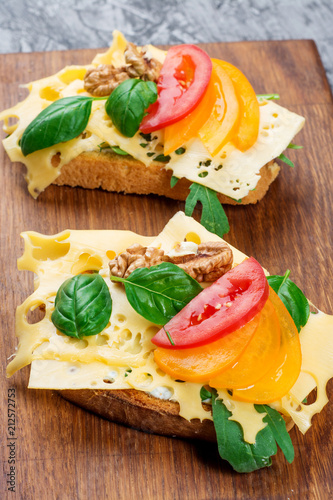 Tomato and basil summer sandwich on kitchen board photo