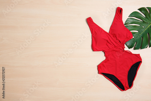 Beautiful swimsuit on wooden background  top view