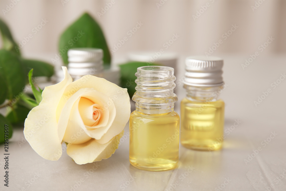 Composition with essential oil and flower on table Composition with essential oil and flower on table