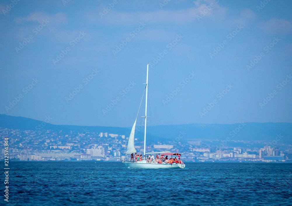 A beautiful yacht with tourists on Board swims along the shore. A beautiful yacht with tourists on Board swims along the shore.