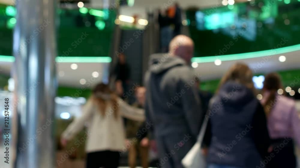 People climb and ride on an escalator inside a shopping center, blurred, moving staircase People climb and ride on an escalator inside a shopping center, blurred, moving staircase