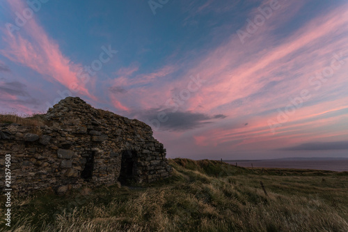 Old stone cottage ruins on the west coast of Ireland at dusk 