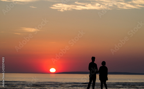 Silhouette of happy couple on the beach at sunset