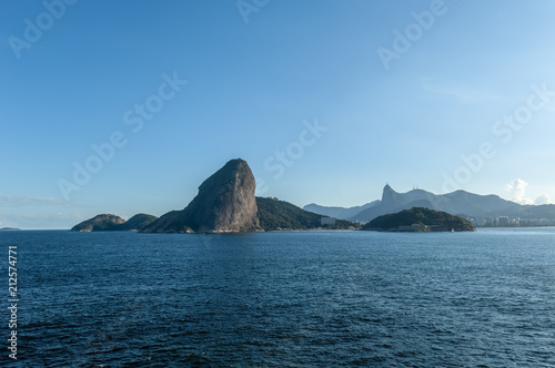 Sugar Loaf, Rio de Janeiro, tourist attraction, back view, a Brazil symbol. Sea, blue sky, boats and stone Pao de Acucar, seen from Niteroi city, located across the Guanabara Bay. photo