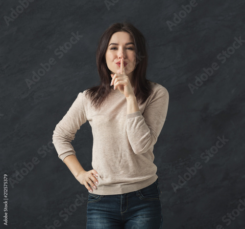 Canvas Print Secret. Young woman put finger on lips, hush sign